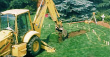 Yellow Backhoe Breaking Ground For Backyard Swimming Pool