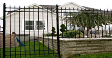 Spear Top Aluminum Fence Panels Used To Create Perimeter Barrier In Conjunction With Landscaping